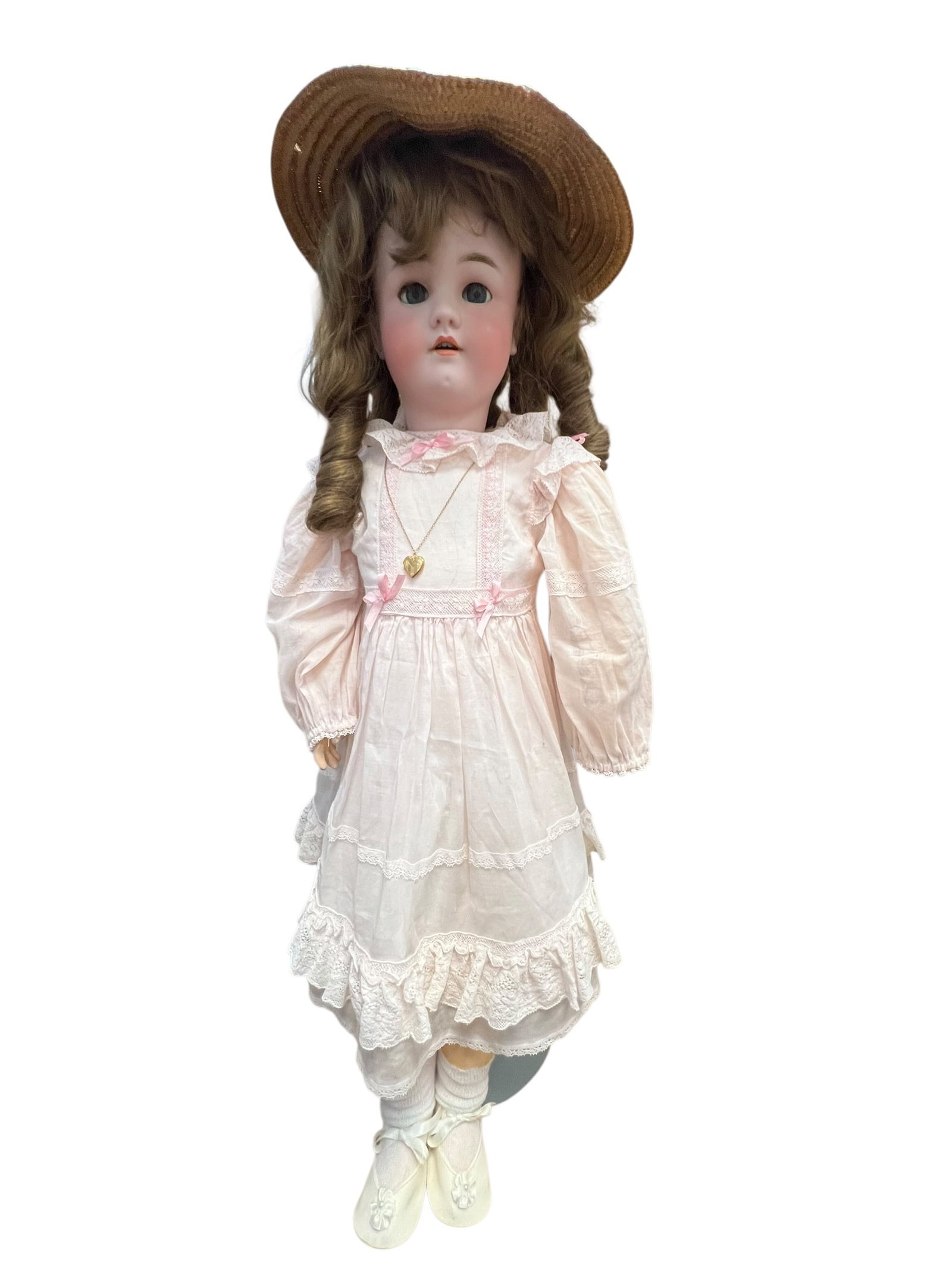 S&H Handwercjk Bisque Head Doll: This item appears to be an antique bisque-head doll from the early 20th century, featuring a pale pink dress and a straw hat. [1, 2]Key FeaturesHead: Crafted from bisque porcelain with delicate