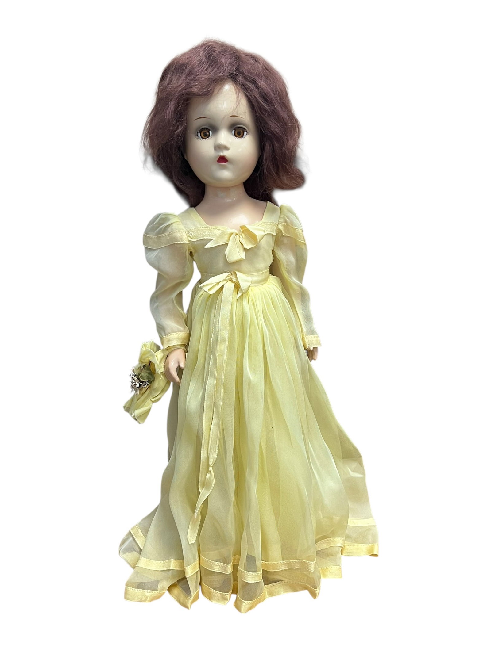 Madame Alexander Doll: vintage composition doll, resembling a 1940s Madame Alexander Wendy Ann bridesmaid doll wearing a yellow sheer gown and holding a matching floral muff. [1, 2]It appears to be made of composition