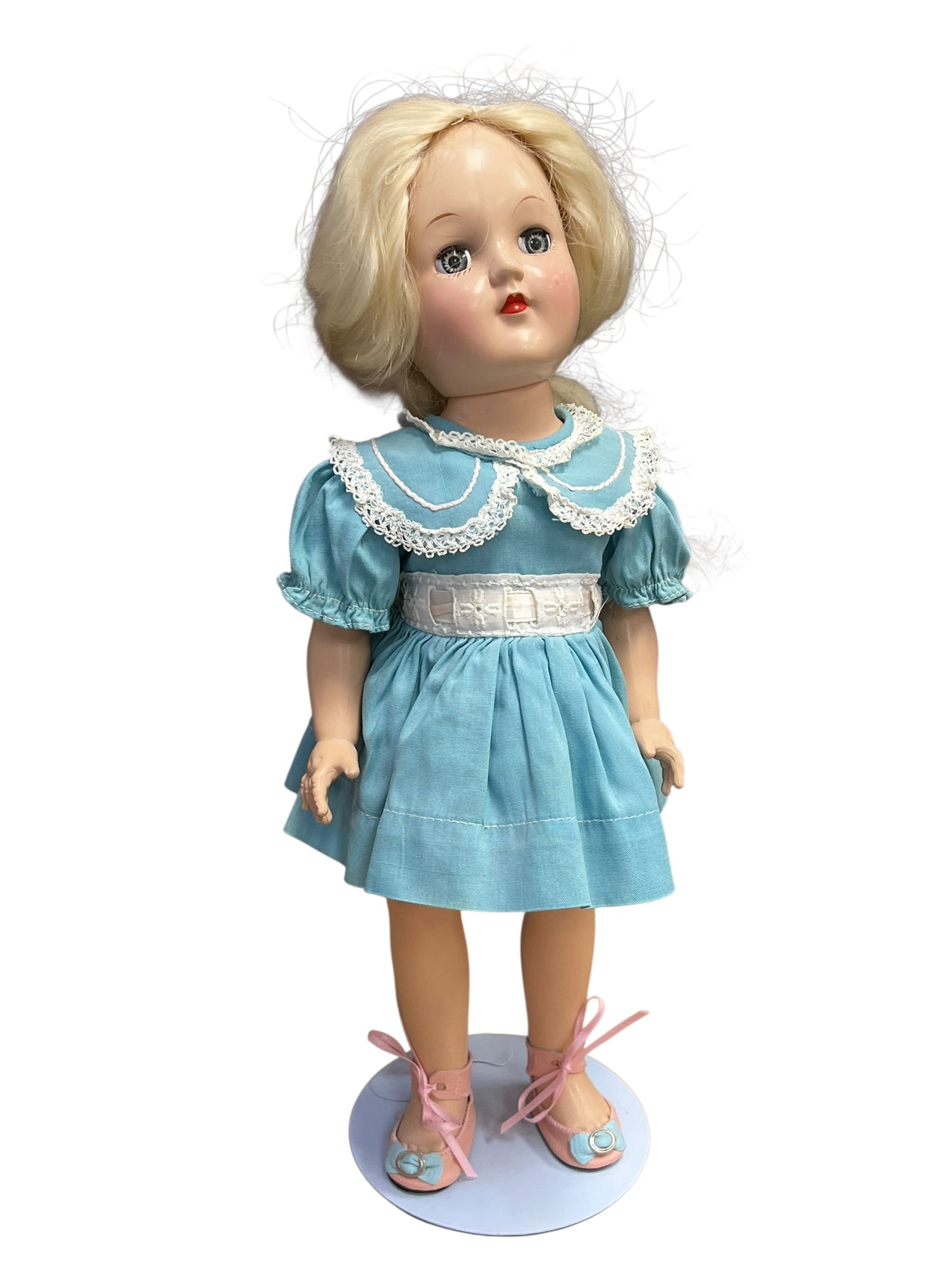 Ideal Genuine Toni Doll: vintage 1950s Ideal P-90 Toni hard plastic doll with blonde hair, blue sleep eyes, and a blue dress with a white lace collar. [1, 2]Doll DetailsMaker: Ideal Toy CorporationModel: P-90 series