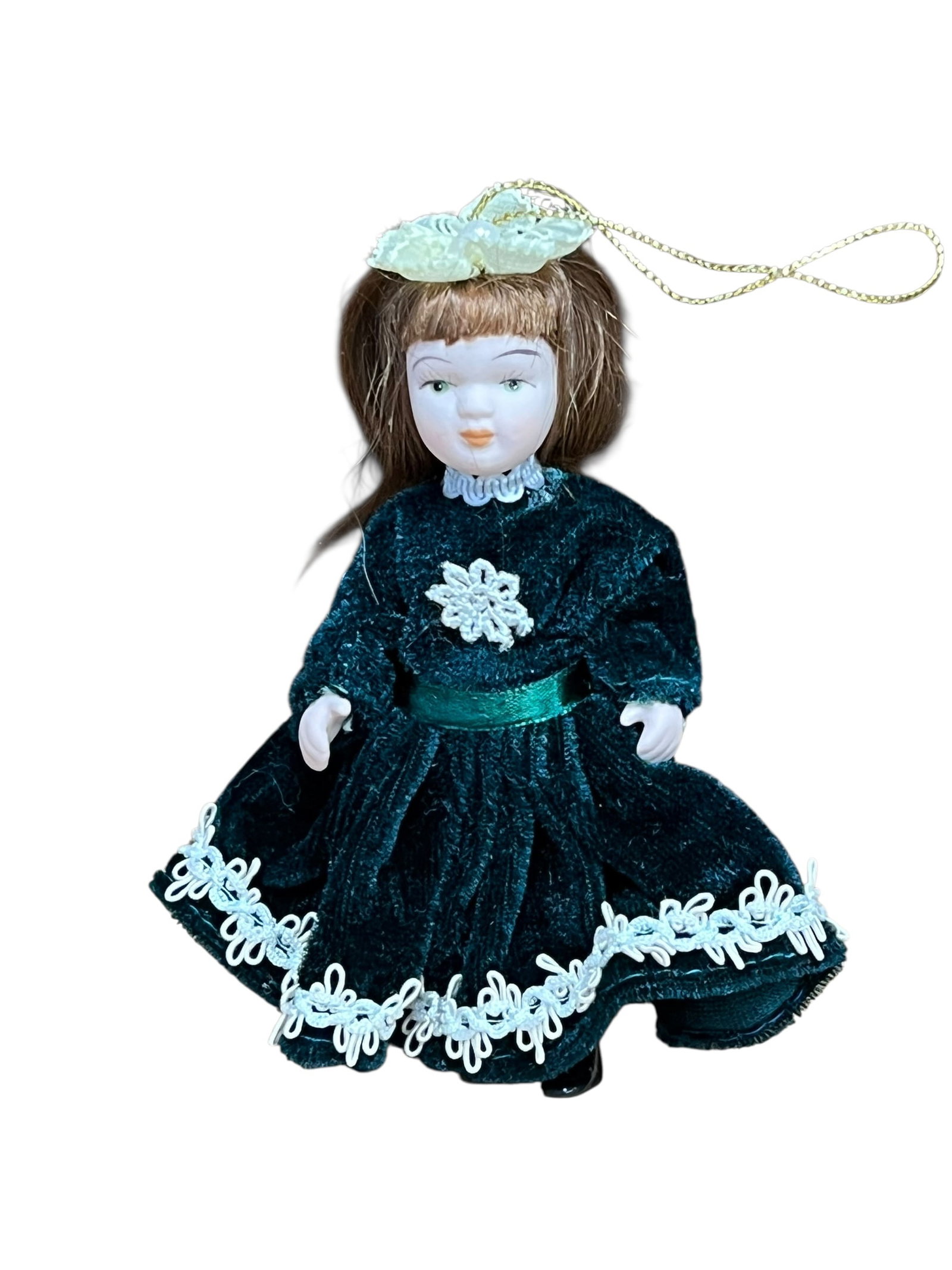 Bisque Head Doll Christmas Tree Ornament: miniature porcelain doll Christmas ornament. The doll features curly auburn or brown hair tied back with a white satin ribbon bow, painted facial features with blue or green eyes, and a full-length cr