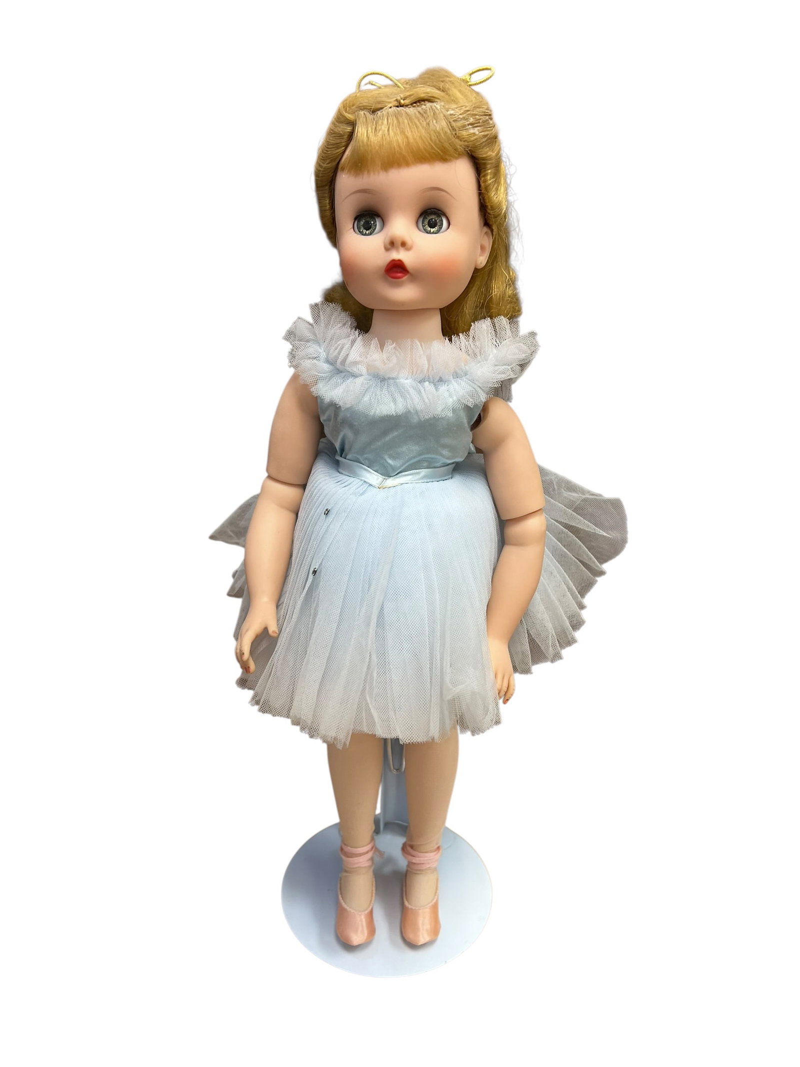 Madame Alexander Vinyl Doll: This vintage doll is a Madame Alexander Elise Ballerina from the 1960s. She stands approximately 17 inches tall and features jointed limbs, a soft vinyl face, bright blue sleep eyes, and blonde hair