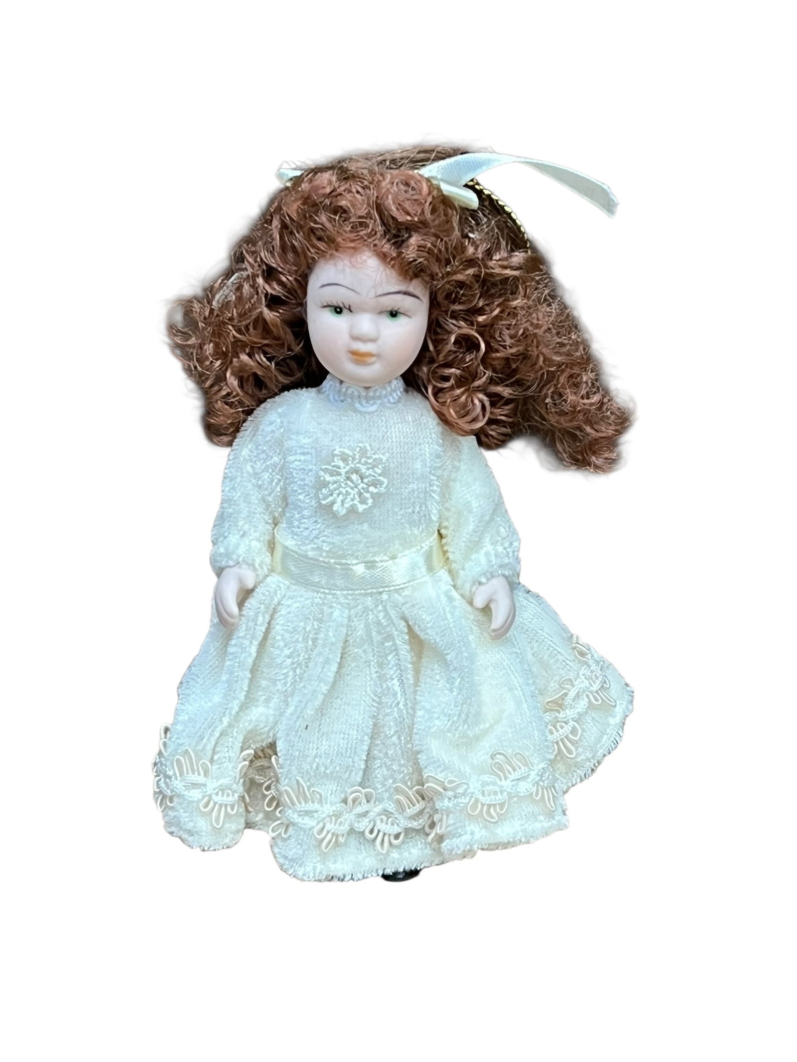 Bisque Head Doll Christmas Tree Ornament: miniature porcelain doll Christmas ornament. The doll features curly auburn or brown hair tied back with a white satin ribbon bow, painted facial features with blue or green eyes, and a full-length cr