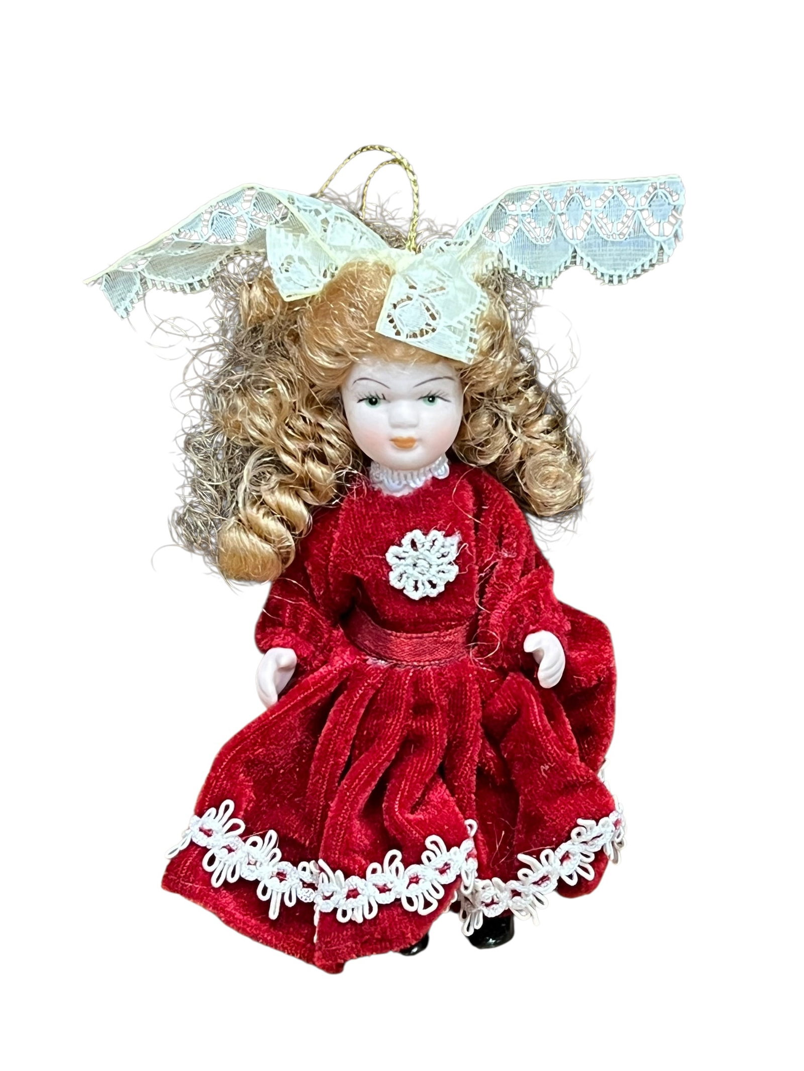 Bisque Head Doll Christmas Tree Ornament: miniature porcelain doll Christmas ornament. The doll features curly auburn or brown hair tied back with a white satin ribbon bow, painted facial features with blue or green eyes, and a full-length