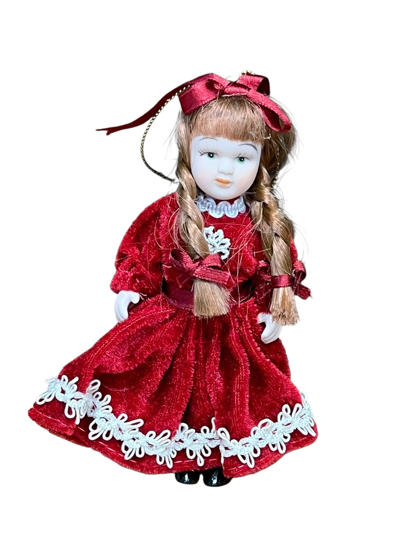 Bisque Head Doll Christmas Tree Ornament: miniature porcelain doll Christmas ornament. The doll features curly auburn or brown hair tied back with a white satin ribbon bow, painted facial features with blue or green eyes, and a full-length