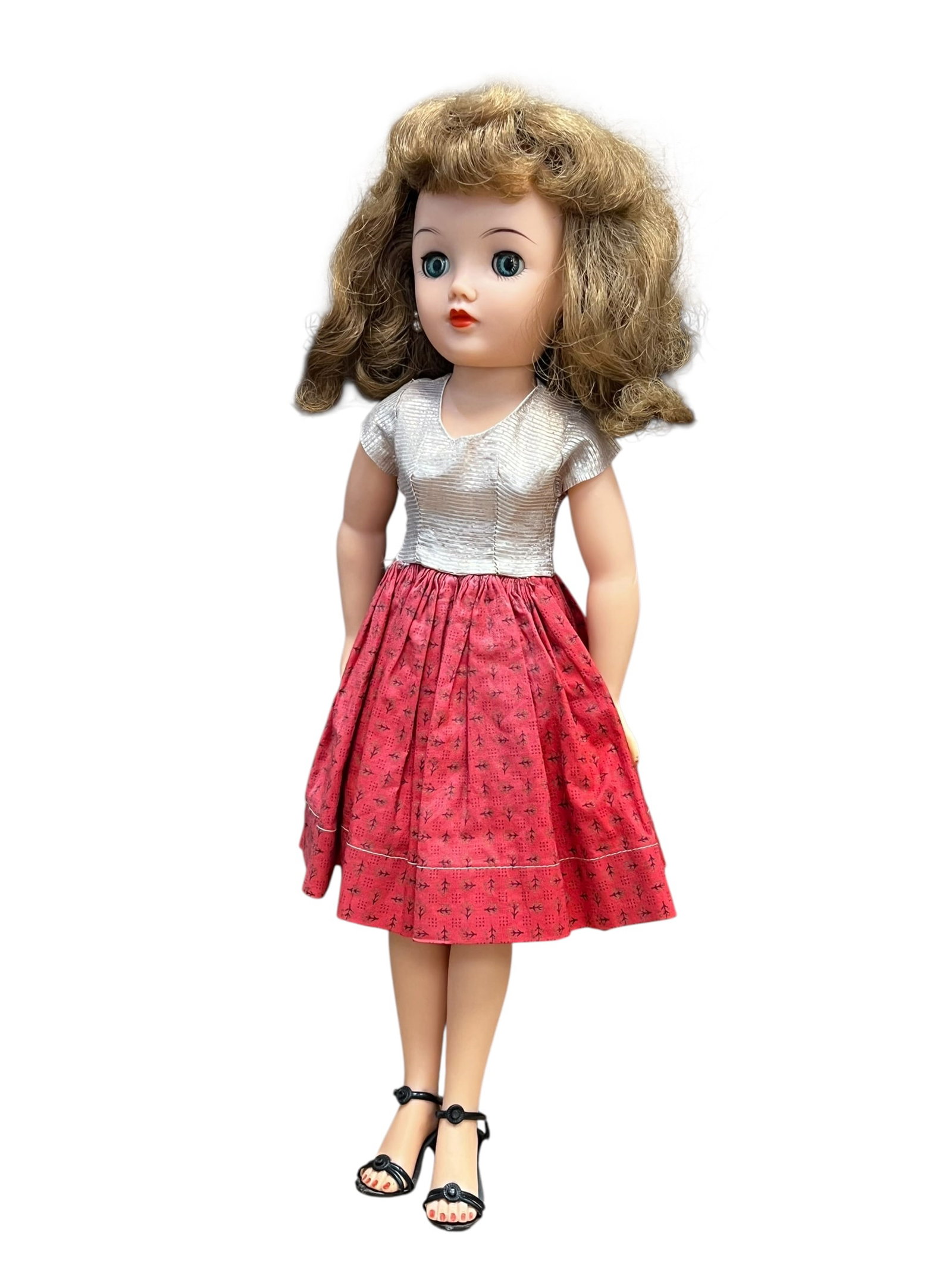 Ideal Miss Revlon Vinyl Doll: vintage Ideal Miss Revlon fashion doll from the 1950s, wearing a silver top and a red patterned skirt. [1]Key DetailsManufacturer: Ideal Toy CorporationEra: Mid-1950s fashion doll lineFeatures: