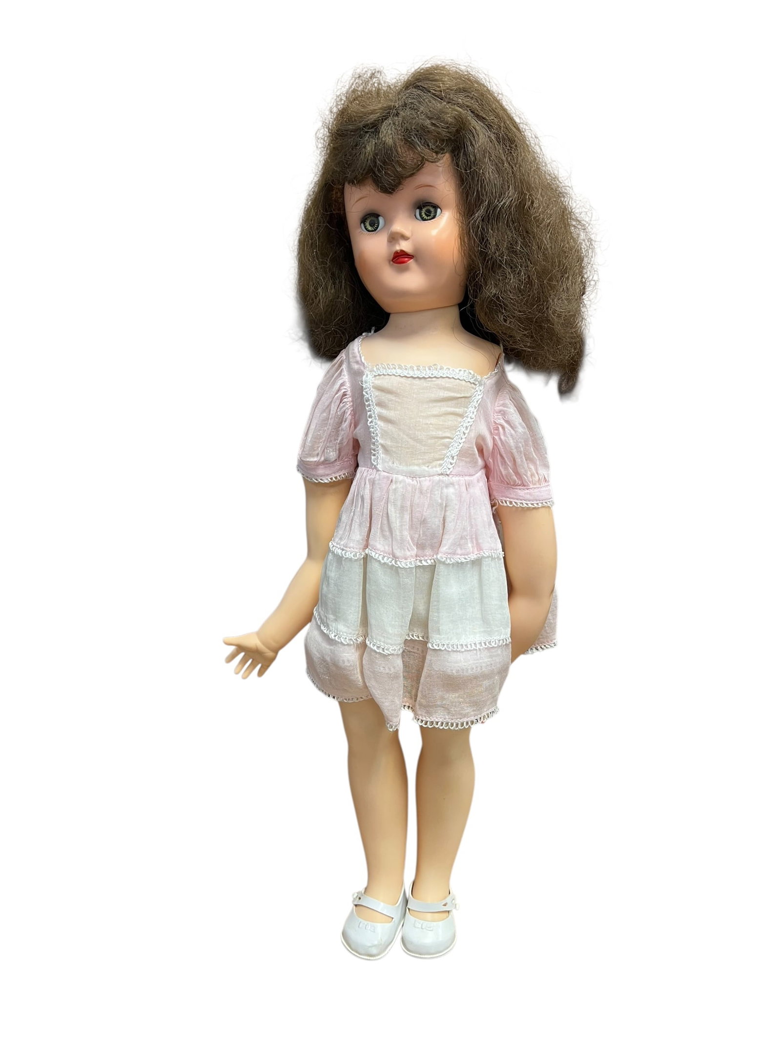 Ideal Plastic Doll: vintage 1950s hard plastic doll, likely a Toni doll made by the Ideal Toy Corporation. [1, 2]Key FeaturesMaterial: Formed from hard plastic with jointed limbs.Facial Details: Features sleep eyes that