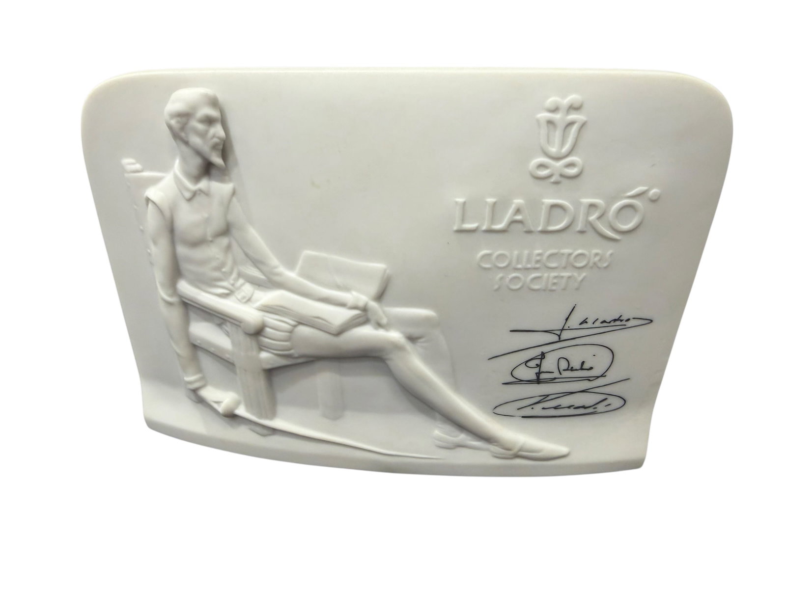 1985 Lladro Collectors Society Don Quixote Porcelain Shell Plaque: Vintage Lladró Collectors Society porcelain plaque, handmade in Spain and dated 1985. The white porcelain plaque features a finely modeled relief depiction of Don Quixote seated with book and sword, 