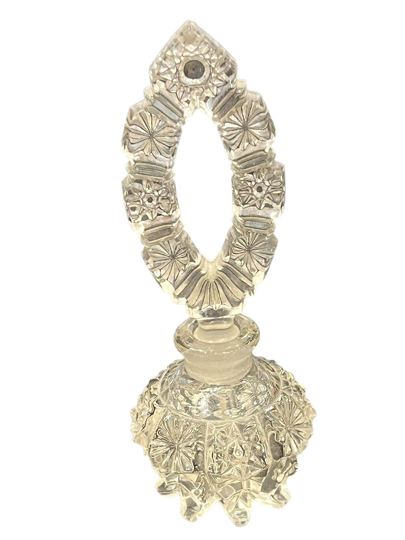 Press Glass Perfume Bottle: Decorative clear cut crystal perfume or cologne bottle featuring a heavily cut, multifaceted body and an elaborate matching stopper. The bottle is decorated with deep geometric cutting, including star