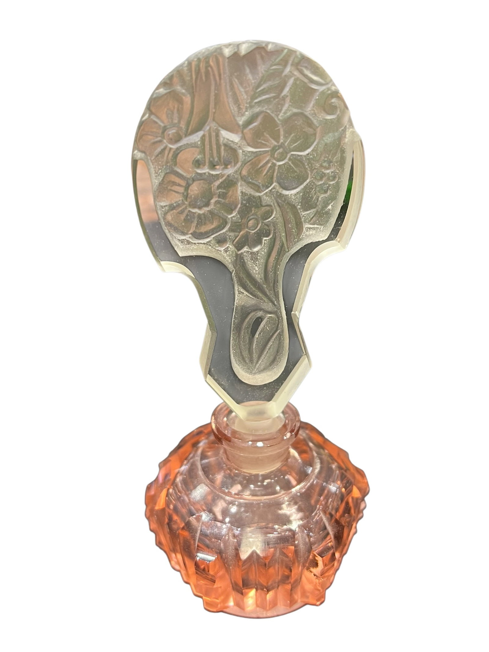 Vintage Pink Depression-Era Style Glass Perfume Bottle with Intaglio Floral Stopper: Attractive vintage-style pressed and cut glass perfume/scent bottle featuring a faceted, pale pink-to-salmon colored body with geometric cutting and a scalloped, jewel-like profile. The bottle is fitt
