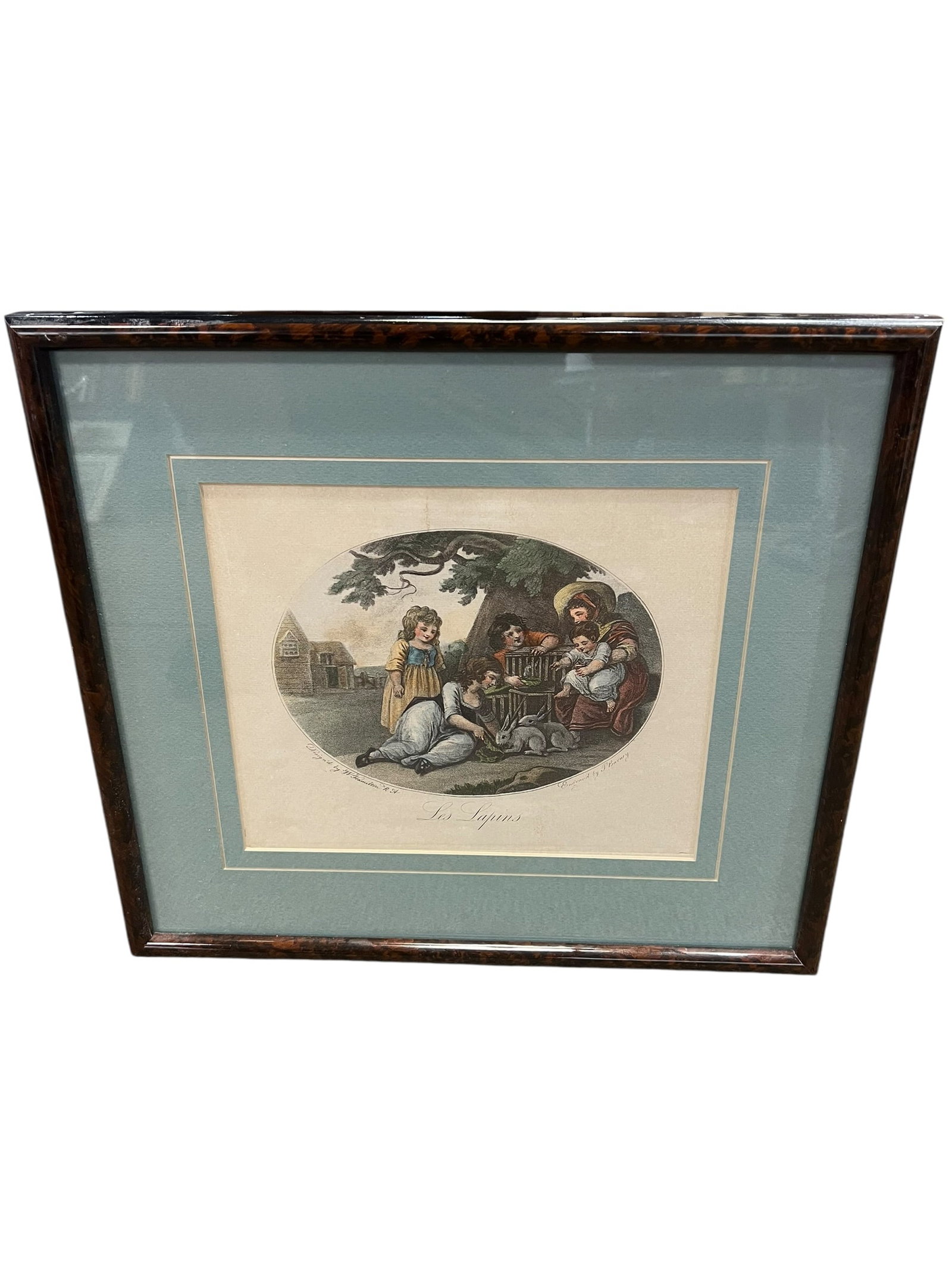 “Les Lapins” After Jean-Baptiste Huet – Hand-Colored Engraving, Framed: Decorative framed hand-colored engraving titled “Les Lapins” (The Rabbits) depicting a charming pastoral scene of a woman and children gathered beneath a tree feeding and tending rabbits. The 