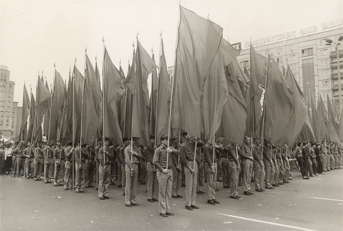 Harald Hauswald. ”1. Mai 1983. Karl-Marx-Allee”. 1983: Harald Hauswald (Radebeul 1954 – lives in Berlin). ”1. Mai 1983. Karl-Marx-Allee”. 1983 Vintage. Gelatin silver print. 26,1 × 38,5 cm (26,6 × 39&nb