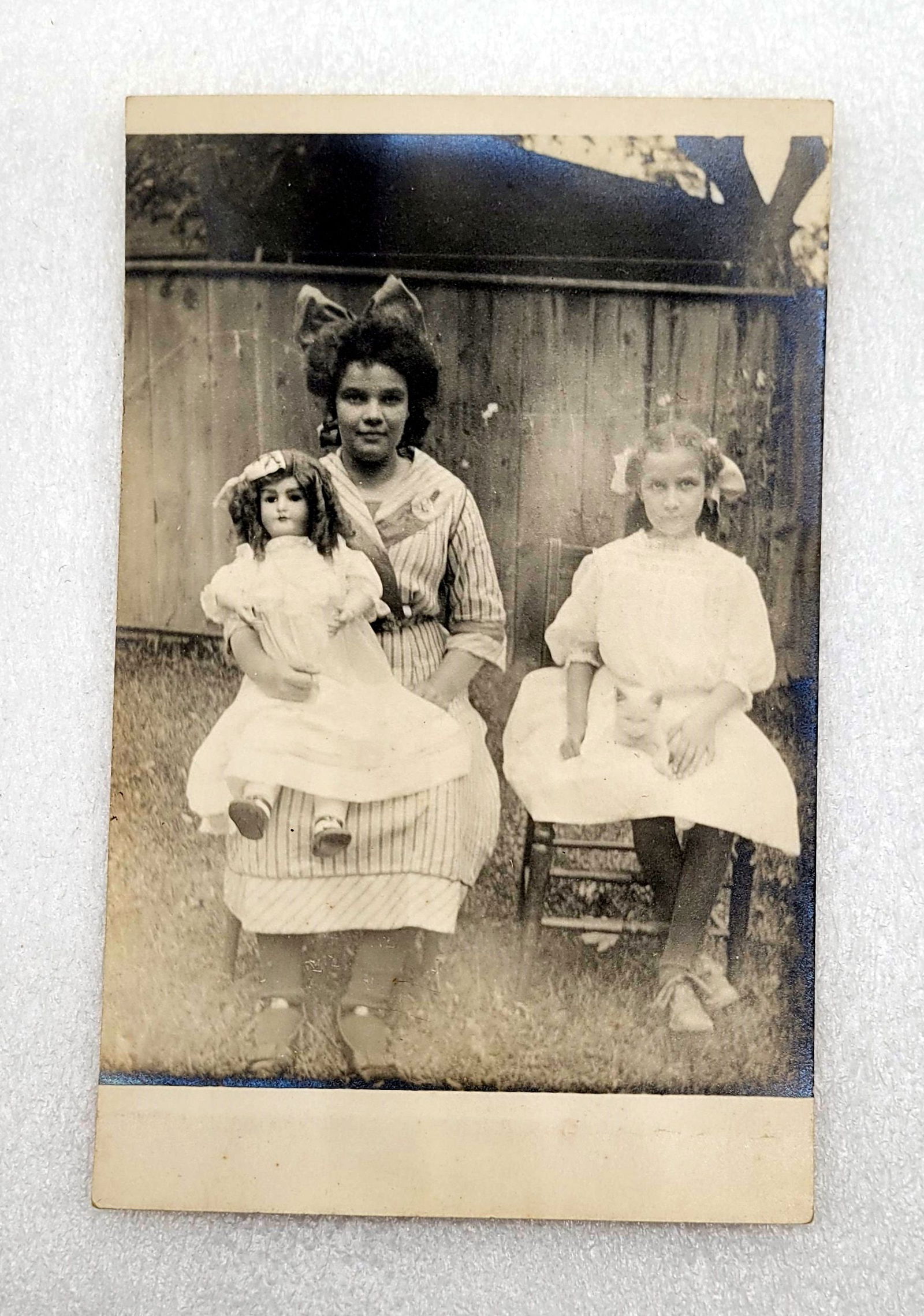 RPPC of Girl w Bisque Doll & Girl w Kitten On Her Lap Bows: RPPC of Girl w Bisque Doll & Girl w Kitten On Her Lap, Bows - 3.5" by 5.5".