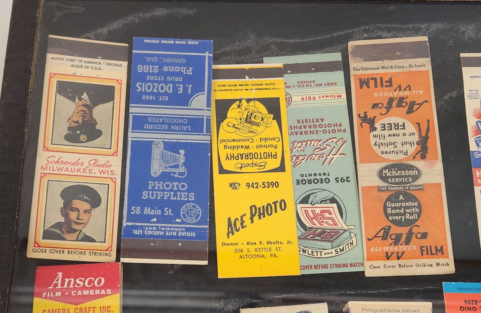 Vintage Photography Matchbooks - Ansco, Agfa, Bell & Howell Framed: Framed and displayed collection of vintage matchbooks from photography related business such as film, cameras, and photo developing services. The frame is approximately 16.5" x 13". The matchbooks are