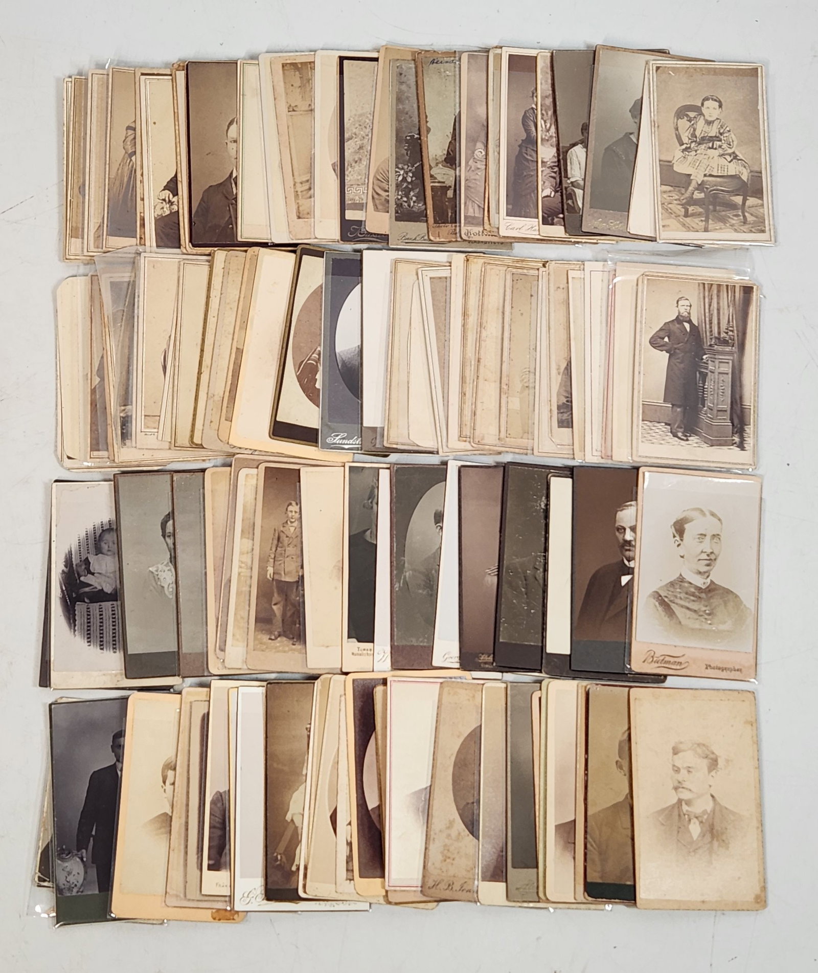 Antique CDV Photo Cards - 80 Piece Vintage Portrait Lot: This is a collection of antique photographs, totaling 80 individual cards. Each card features sepia-toned images of various people, with many bearing the photographer's name and location on the revers