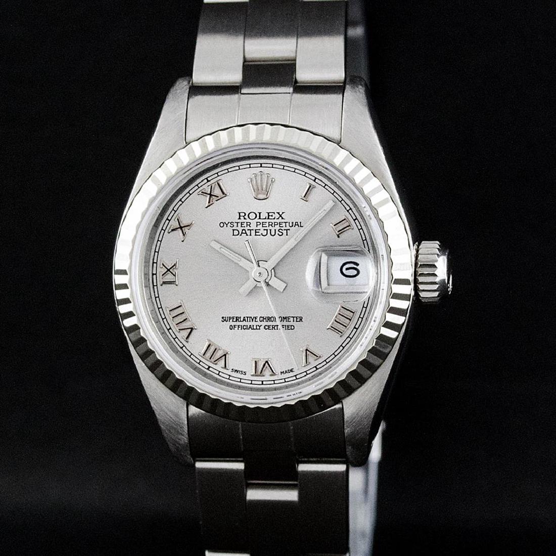 Rolex SS Silver Roman With Square Track Oyster Band: One Ladies Rolex Datejust Polished Bright with Satin Finish, Serviced & Electronically Tested, Stainless Steel Case:26mm, Stainless Steel Crown, Bezel:14K White Gold Fluted. Custom Crystal: Acrylic Cy