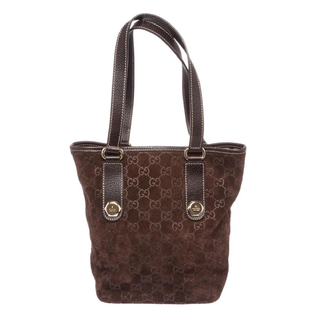 Gucci Brown Suede Monogram Leather Tote Bag: One Gucci Brown Suede Monogram Leather Tote Bag. Overallip top closure. Interior contains fabric lining with one side cellphoneip pocket and one side zipper pocket. Exterior contains gold-tone embelli