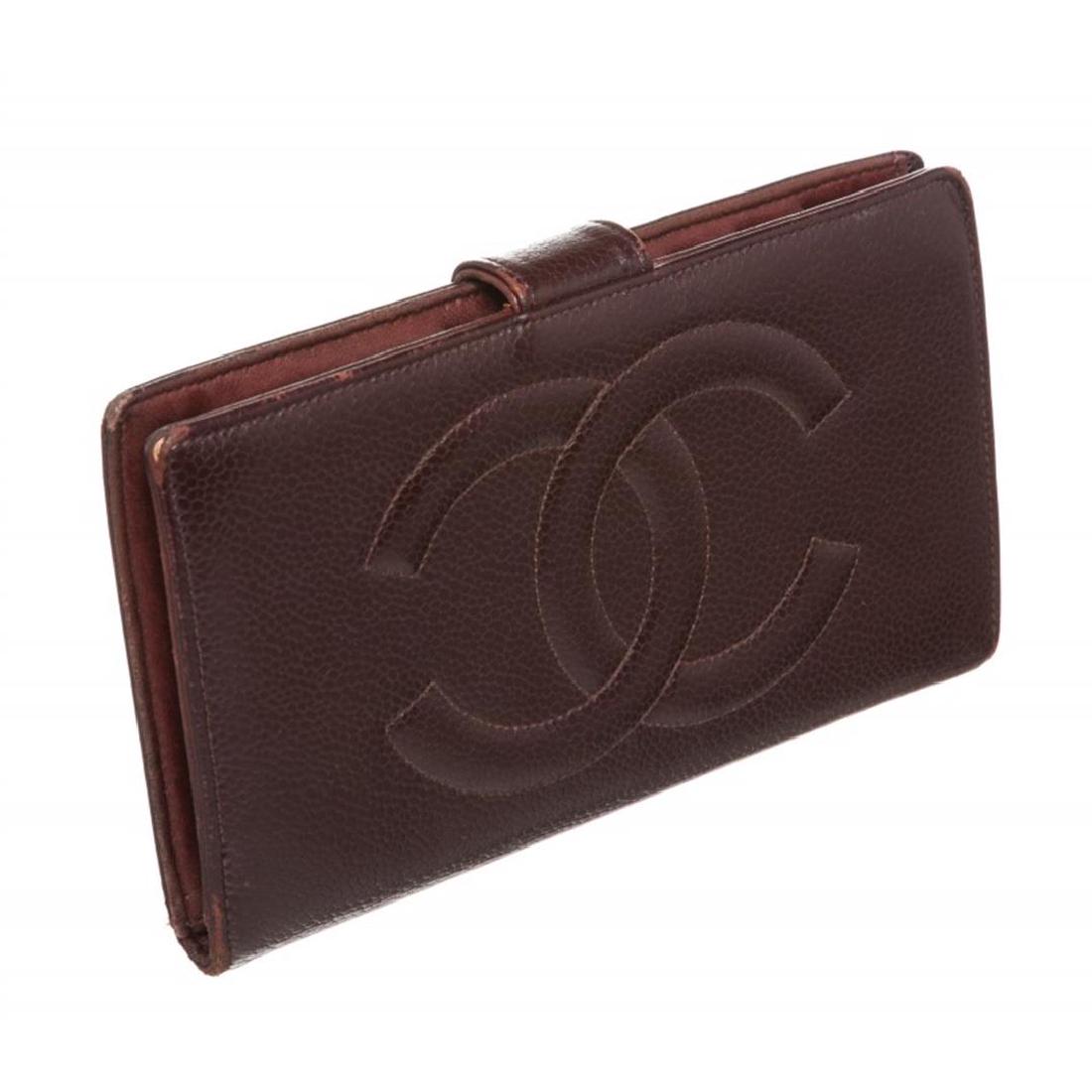Chanel Burgundy Caviar CC Logo Leather Long Wallet: Overall flap snap closure. Interior is leather lined and contains six credit cardip pockets, three billfold compartments and coin pocket with push snap closure. Exterior contains CC stitching on back.