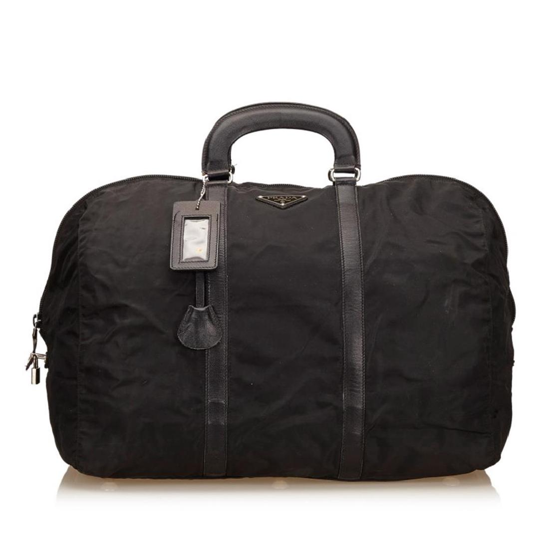 Prada Black Nylon Leather Double Handle Zipper Travel: This duffel bag features a nylon body, structured leather handles, a top zip closure, and an interior zip pocket.