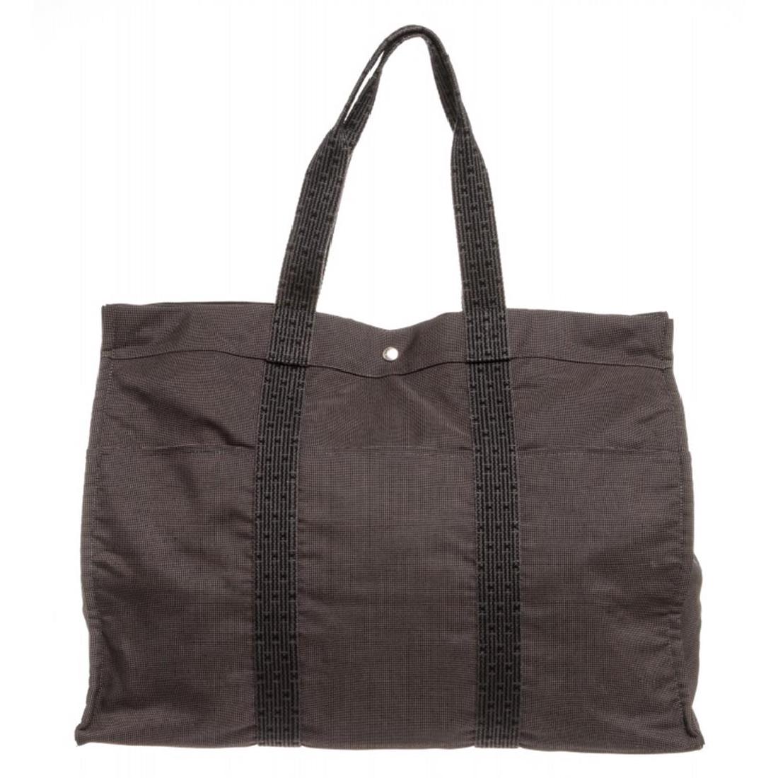 Hermes Gray Canvas Sac Fourre XL Tote Bag: Overall zipper and snap button closure. Interior is tonal canvas lined and contains four sideip pocket. Exterior contains sixip pockets.