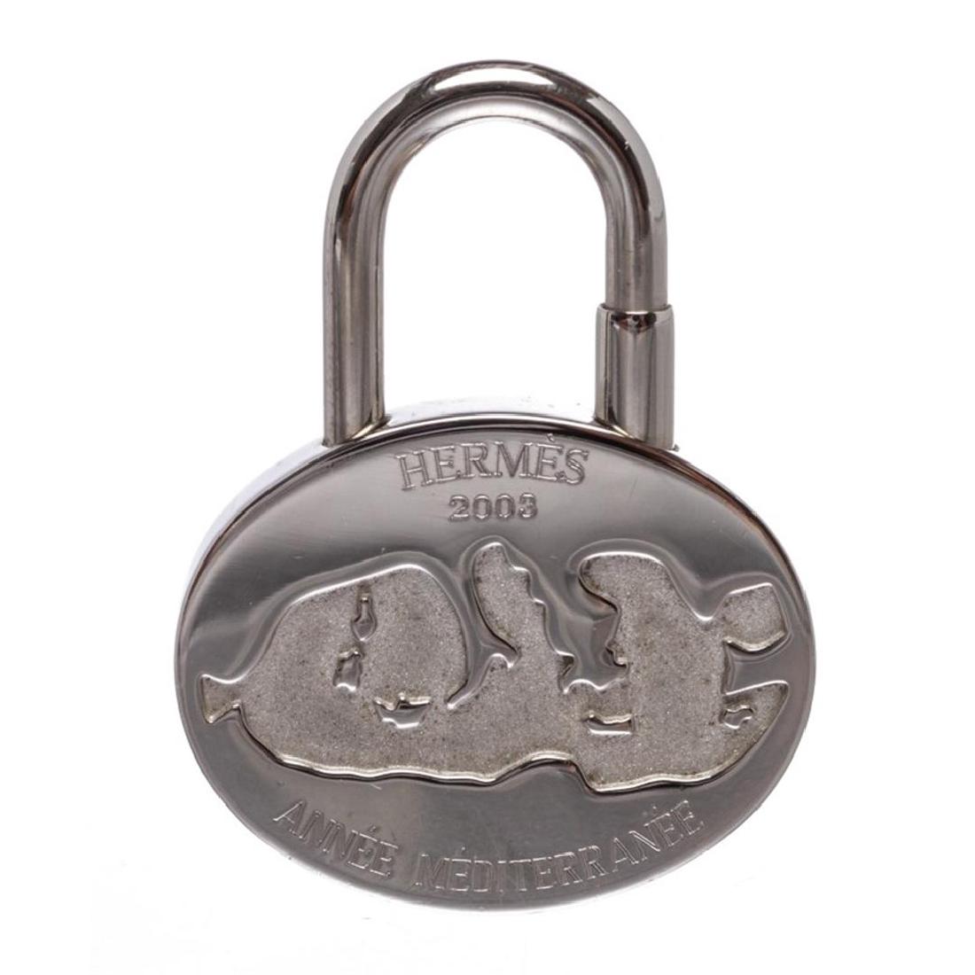 Hermes Silver Palladium Année Méditerranée Lock Charm: One Hermes Silver Palladium Année Méditerranée Lock Charm. Crafted out of silver palladium lock charm with screw closure.