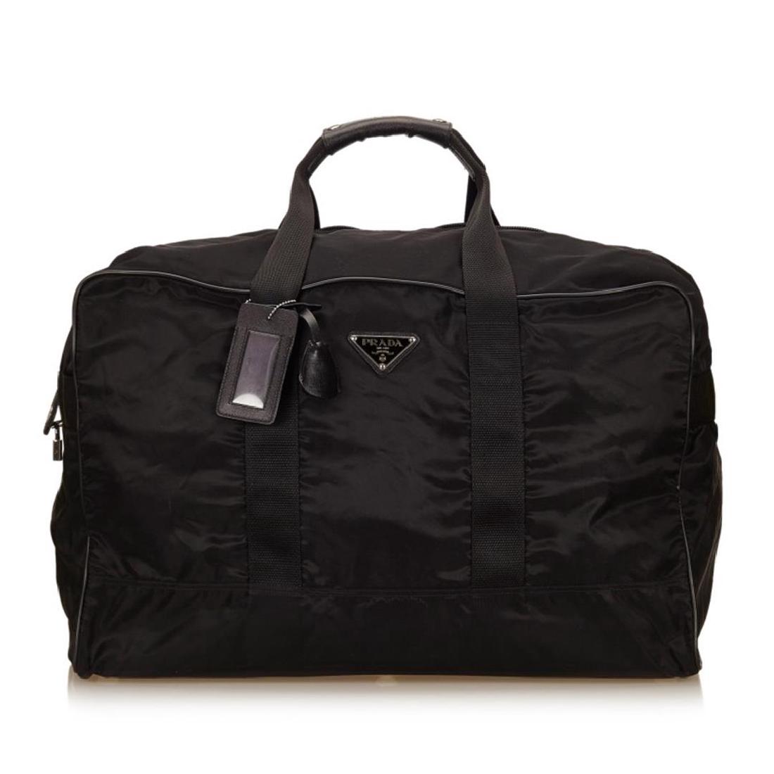Prada Black Nylon Leather Zipper Travel Duffle Bag: This duffel bag features a nylon body with leather trim, flat handles, and top zip closure. Item is pre-owned.