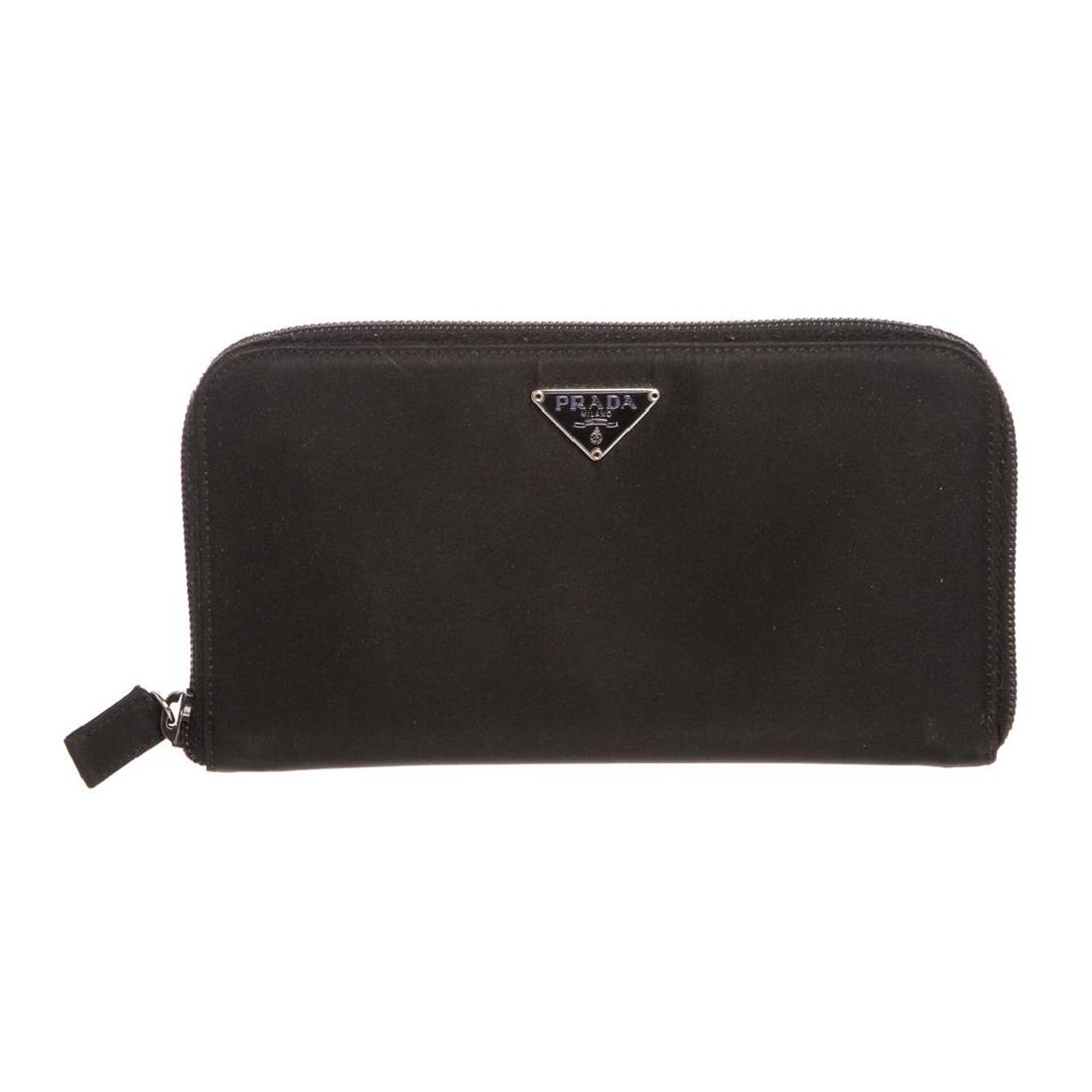 Prada Black Nylon Leather Zipper Wallet: Black Prada nylon leather zipper wallet with black leather lined interior, two side slip pockets, eight card slots, two large open compartments and one large zipper pocket.