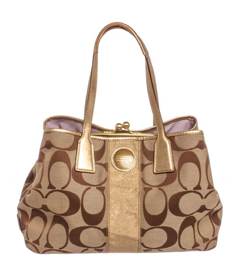 Coach Brown Monogram Canvas Gold Metallic Leather Trim: Overall kiss lock top closure. Interior is lilac satin lined with a dual slip pockets and one side zip pocket. Exterior gold metallic leather trim and leather shoulder flat straps.