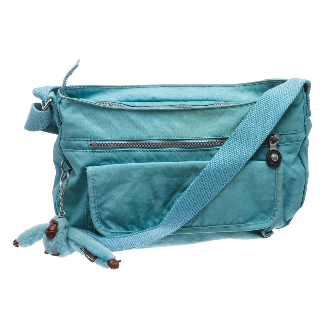 Kipling Blue Nylon Crossbody Messenger Bag: Overall zipper closure with hanging gorilla purse charm. Interior contains nylon lining with two compartments, two slip pockets, three pen holders and one zipper pocket. Exterior contains front velcro