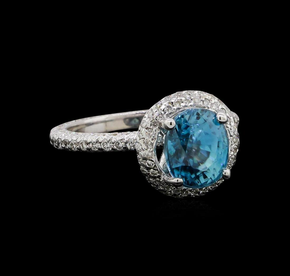 4.23 ctw Blue Zircon and Diamond Ring - 14KT White Gold: One electronically tested 14KT white gold ladies cast blue zircon and diamond ring with a bright polish finish. The featured blue zircon is set within a diamond bezel supported by a diamond under gall