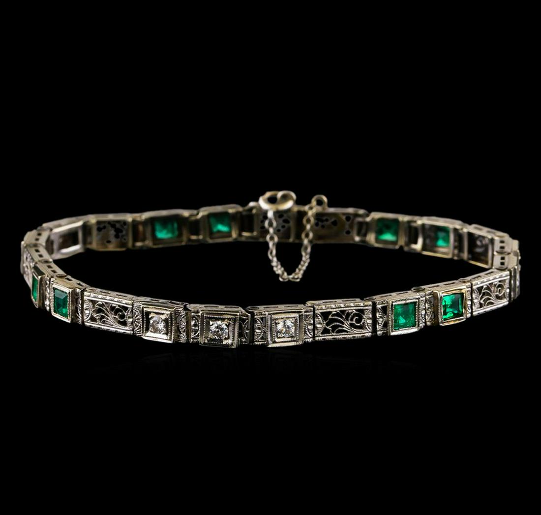 1.30 ctw Emerald and Diamond Bracelet - 18KT White Gold: One electronically tested 18KT white gold ladies cast & assembled emerald and diamond bracelet. Seven and one-eighth inch length bracelet features a flexible emerald and diamond ribbon with filagree a
