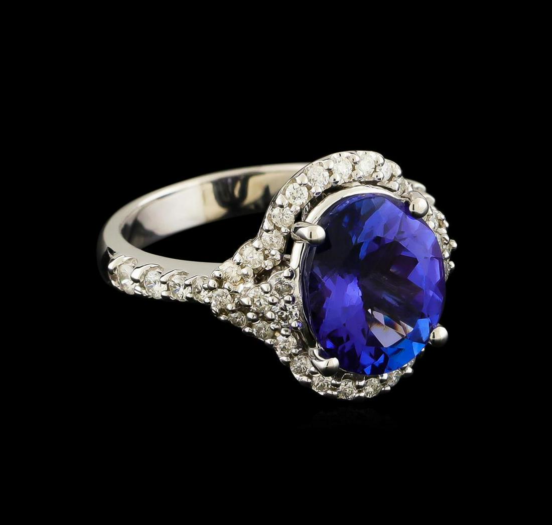 3.60 ctw Tanzanite and Diamond Ring - 14KT White Gold: One electronically tested 14KT white gold lady's combination cast & assembled fashion ring with a halo with a bright polish finish. The featured lady's ring has a shank measuring 3.11 millimeters wide