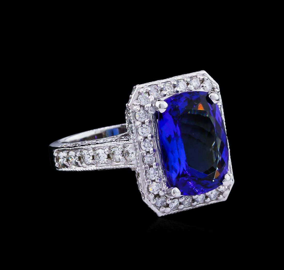 4.85 ctw Tanzanite and Diamond Ring - 14KT White Gold: One electronically tested 14KT white gold lady's cast fashion ring with a cathedral shank with a halo with a bright polish with milgrain detailing finish. The featured lady's ring has a shank measurin