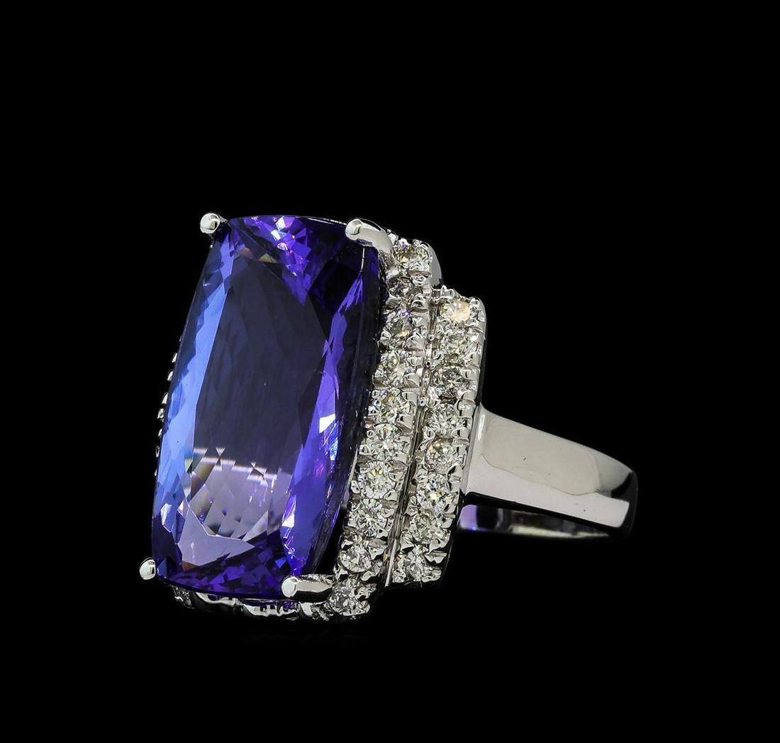 11.78 ctw Tanzanite and Diamond Ring - 14KT White Gold: One electronically tested 14KT white gold ladies cast tanzanite and diamond ring with a bright polish finish. The featured tanzanite is set between tiered diamond ribbons, completed by a two millimete