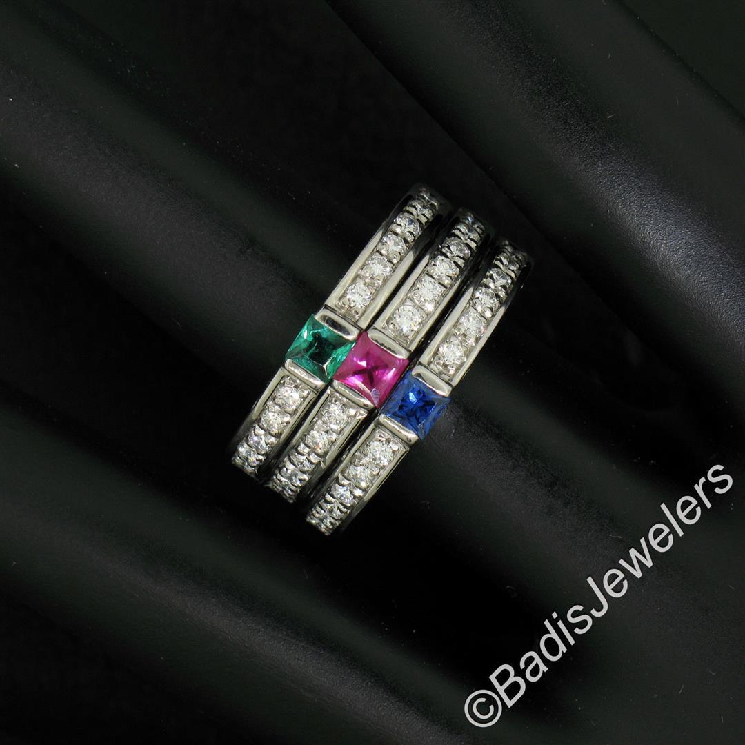 Set of 3 Stackable 18kt White Gold Emerald Ruby: An excellent condition set of 3 18kt white gold band rings with each featuring a different princess cut gemstone (0.16ct ruby, 0.13ct sapphire, and 0.10ct emerald) and 0.20ctw of round diamonds (F/G -