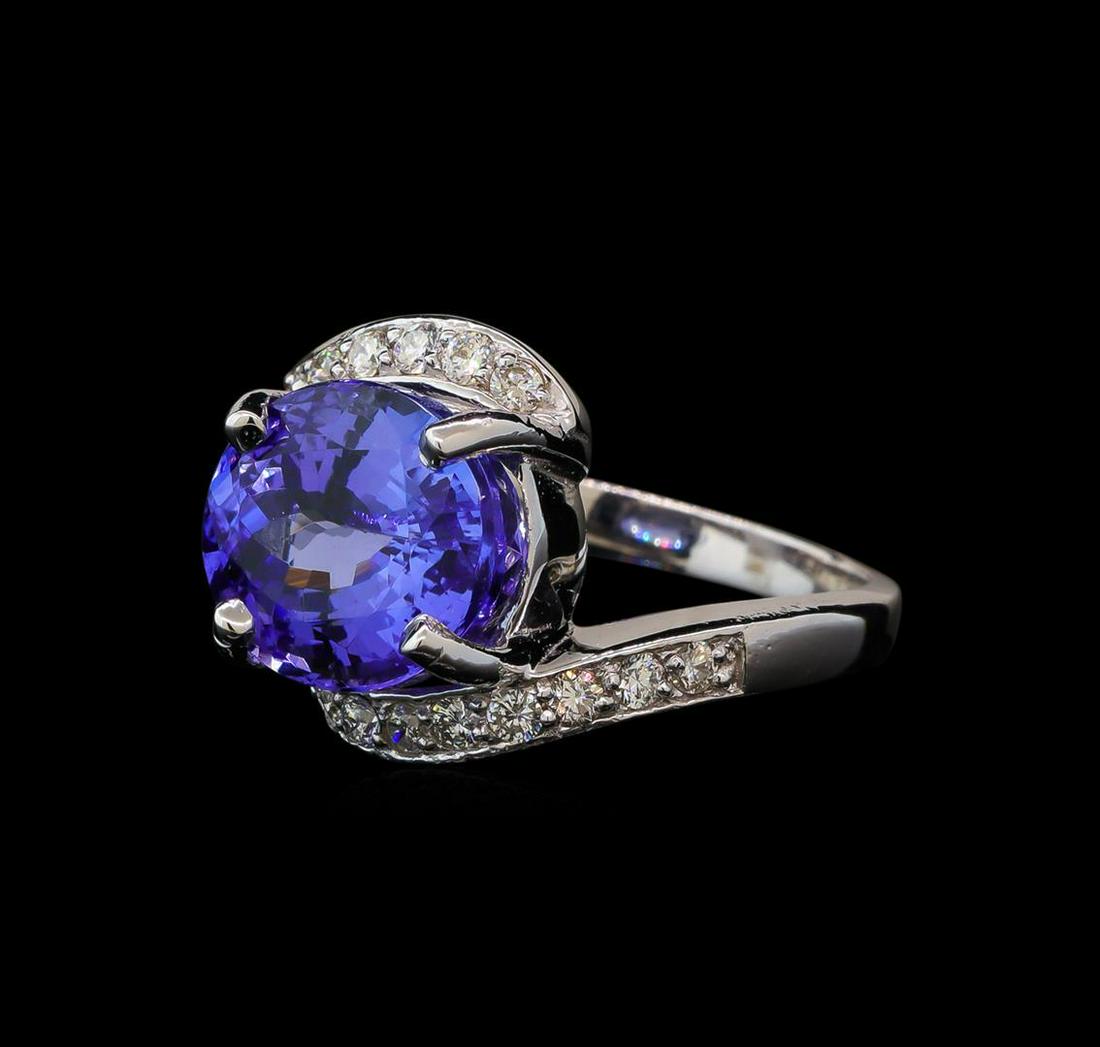 6.82 ctw Tanzanite and Diamond Ring - 14KT White Gold: One electronically tested 14KT white gold lady's cast fashion ring with a bypass shank with a bright polish finish. The featured lady's ring has a shank measuring 2.31 millimeters wide. Identified wit