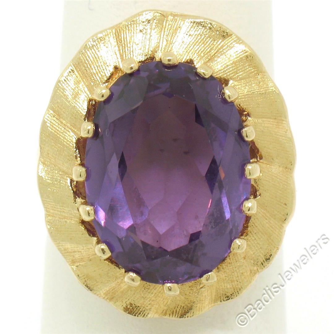 Vintage 14kt Yellow Gold Oval Synthetic Alexandrite: An excellent condition 14kt yellow gold ring set with an oval cut 9.27ct synthetic alexandrite surrounded by a scalloped and textured frame. The ring is size 6.5, weighs a total of 8.84 grams, and mea