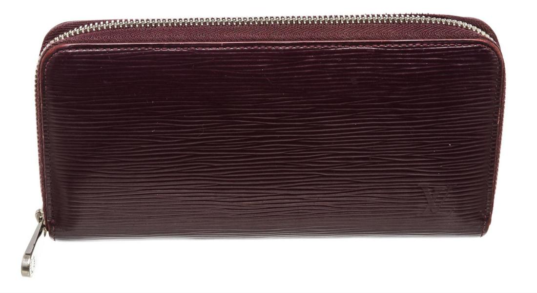 Louis Vuitton Purple Epi Leather Zippy Wallet: Purple Epi leather Louis Vuitton Zippy wallet with silver-tone hardware, tonal leather interior, five compartments; one with zip closure, dual bill compartments, eight card slots and zip-around closur