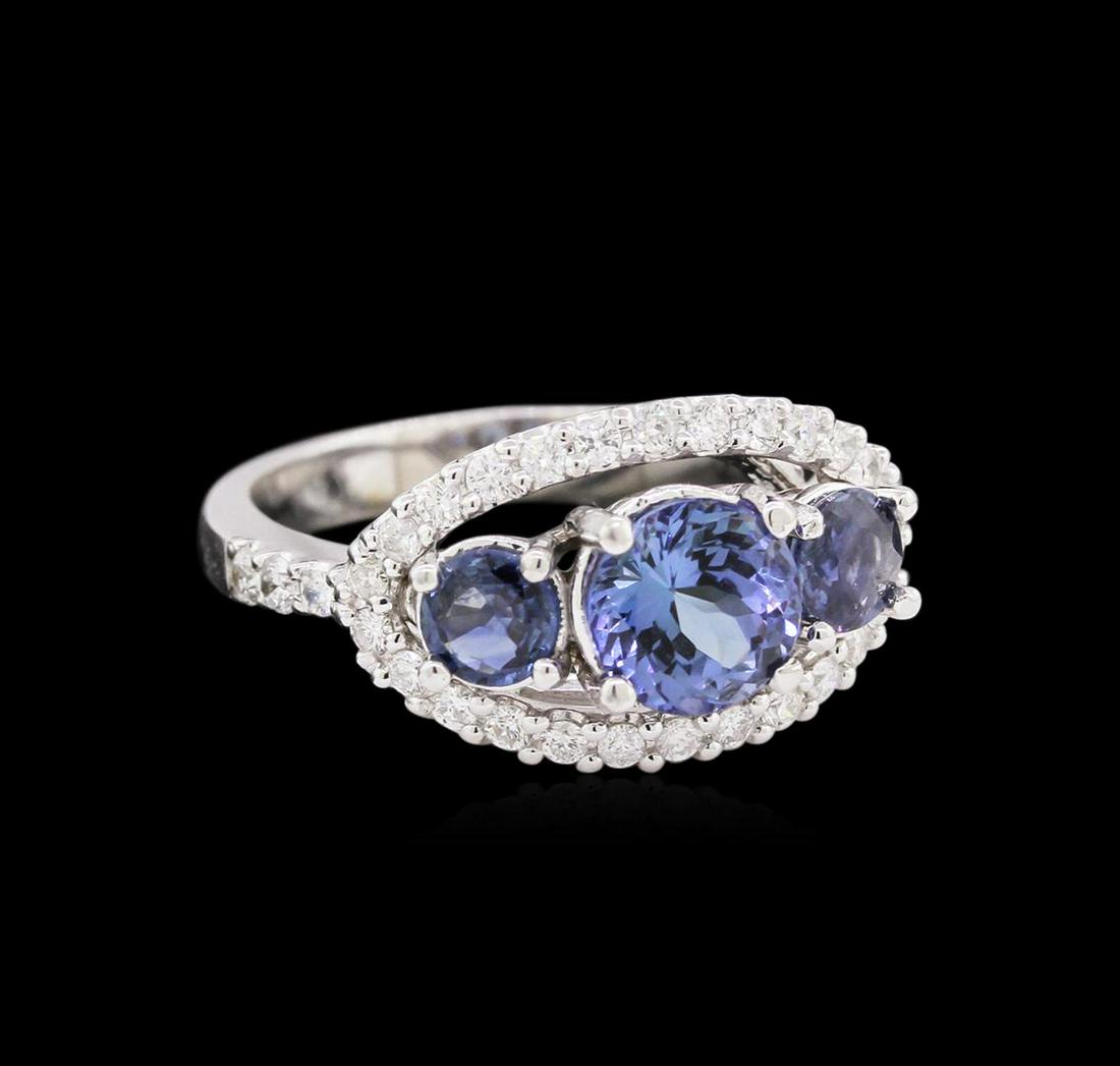 1.27 ctw Tanzanite, Sapphire and Diamond Ring - 14KT: One ring featuring: 14KT white gold weighing 4.58 grams containing one tanzanite with a total weight of 1.27ct and 2 blue sapphires with a total weight of 0.61ct and side diamonds with a total weight 