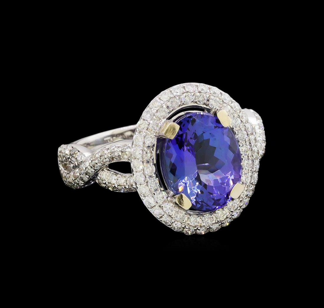 14KT White Gold 3.21 ctw Tanzanite and Diamond Ring: One electronically tested 14KT white gold ladies cast tanzanite & diamond ring with a bright finish. The featured tanzanite is set within a diamond bezel, supported by intertwined diamond set ribbons,