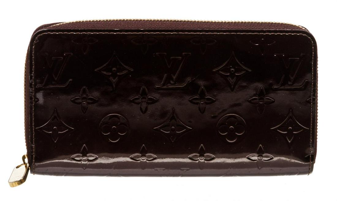 Louis Vuitton Amarante Vernis Monogram Zippy Wallet: Monogram Vernis leather Louis Vuitton Zippy wallet with brass hardware, tonal leather lining, four interior compartments; one with zip closure, three bill compartments, eight card slots and zip-around
