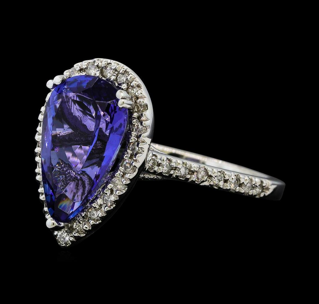 3.45 ctw Tanzanite and Diamond Ring - 14KT White Gold: One electronically tested 14KT white gold lady's cast fashion ring with a cathedral halo with a bright polish finish. The featured lady's ring has a shank measuring 1.80 millimeters wide. Identified w