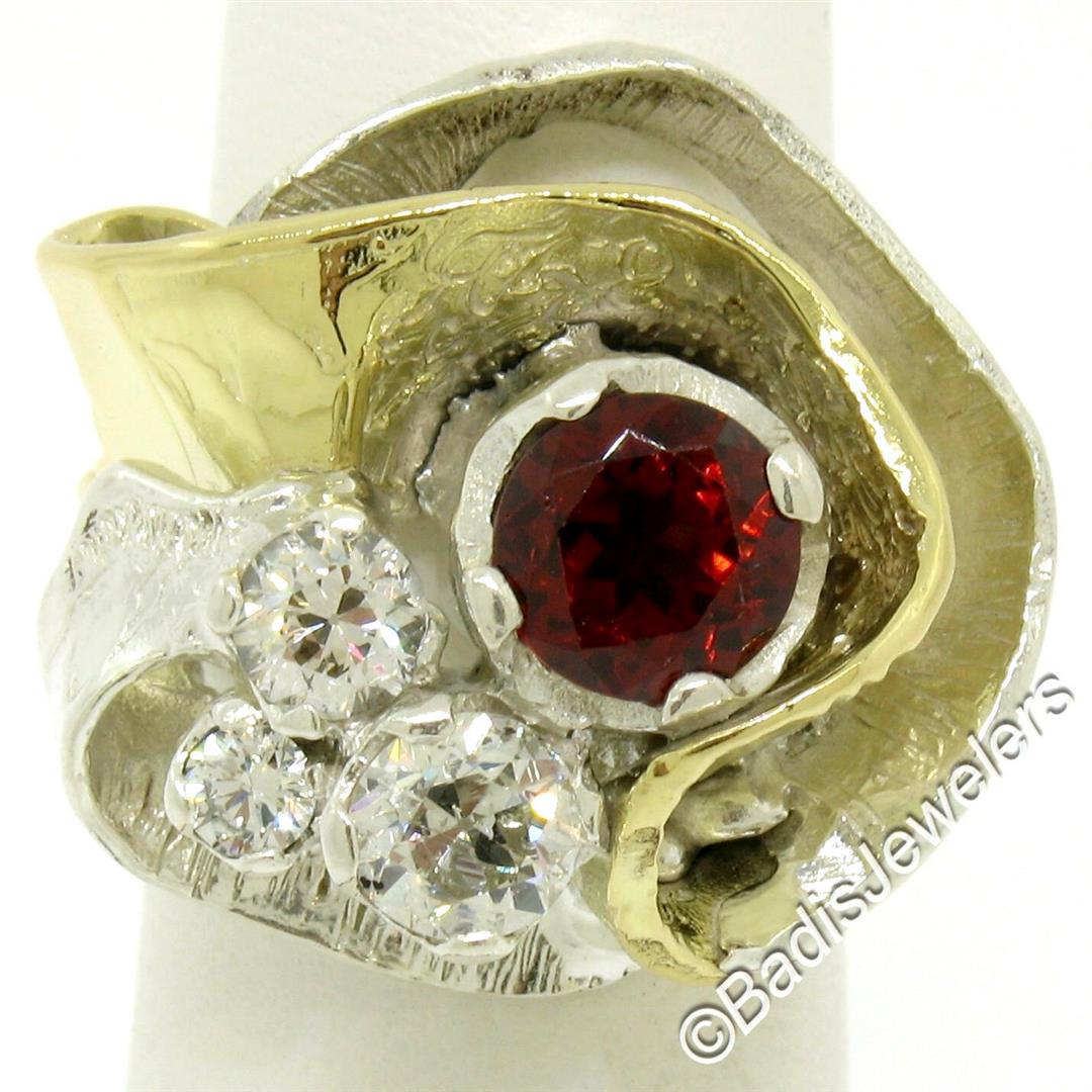 18kt Yellow Gold and Sterling Silver 2.73 ctw Garnet: A large 18kt yellow gold and sterling silver cocktail ring with a 1.60ct round garnet accented by 1.13ctw of round diamonds (F/G - VS2/SI1). The ring is size 5.5, weighs a total of 18.76 grams, and me
