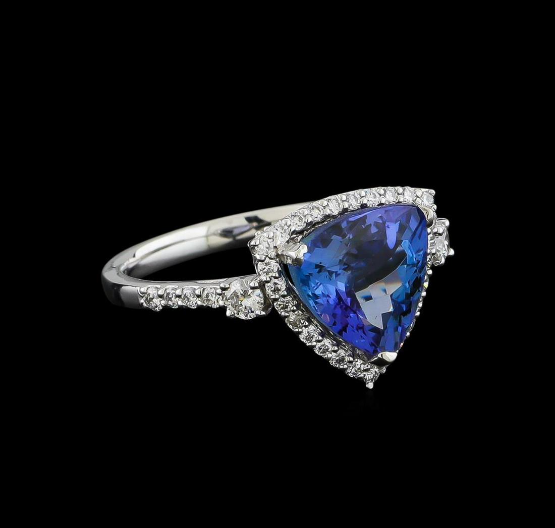 3.60 ctw Tanzanite and Diamond Ring - Platinum: One electronically tested platinum ladies cast tanzanite and diamond ring with a bright polish finish. The featured tanzanite is set within a diamond bezel supported by a diamond set under gallery and