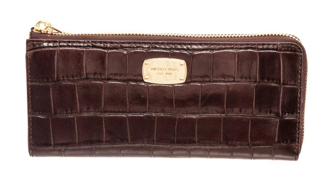 Michael Kors Brown Crocodile Embossed Leather Zippy: Michael Kors brown crocodile embossed leather zippy wallet with gold-tone hardware, logo placard at front, five interior compartments; one with zip closure, eight cardholder slots and overall zip arou