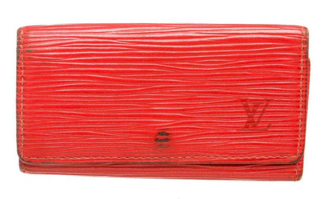 Louis Vuitton Red Epi Leather 4 Key Holder: Red Epi leather Louis Vuitton 4 key holder with gold-tone hardware, debossed logo at front, tonal leather interior, four key clasps and snap closure at front flap. Measurements: Length: 4.25 in / 11 c