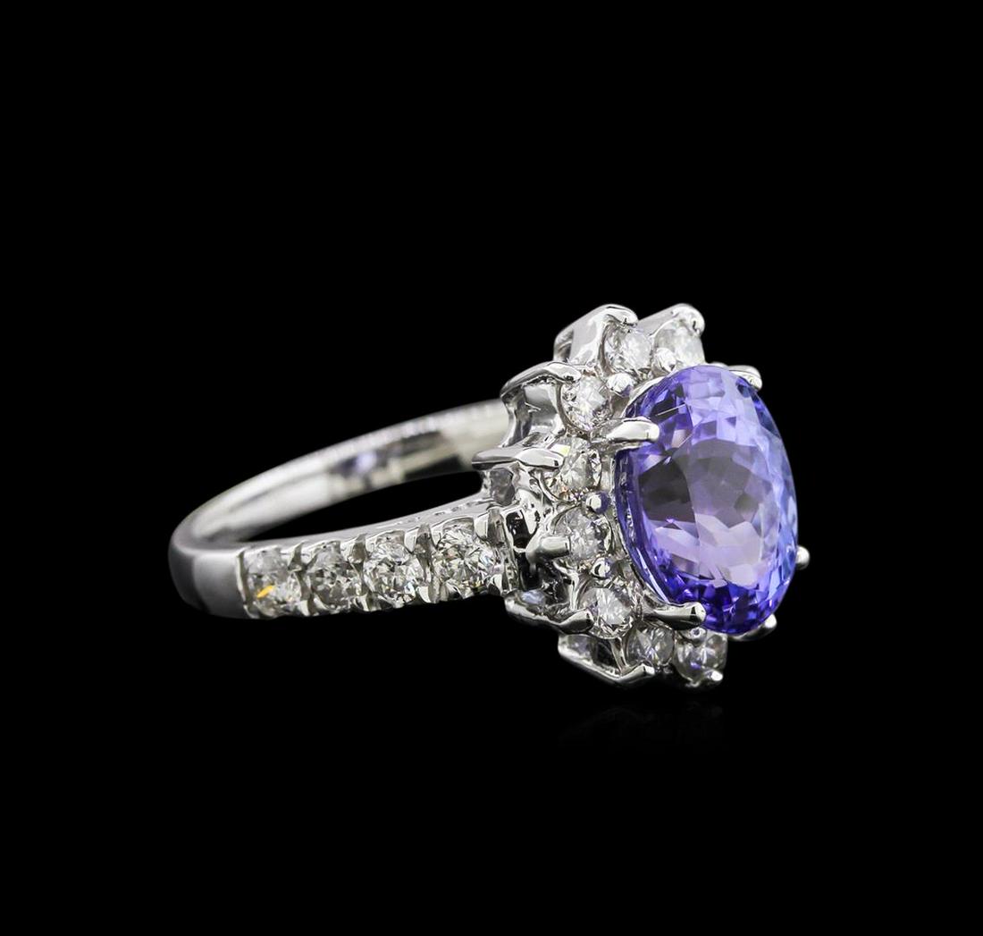 2.97 ctw Tanzanite and Diamond Ring - 14KT White Gold: One electronically tested 14KT white gold lady's cast fashion ring with a halo with a bright polish finish. The featured lady's ring has a 1.95 millimeter wide shank. Identified with markings of "K14"