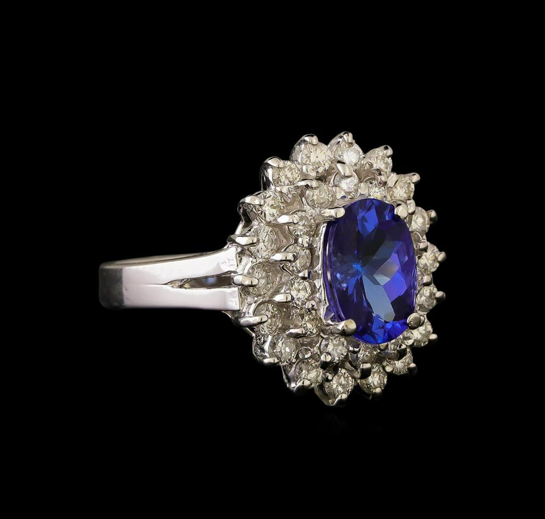 14KT White Gold 1.65 ctw Tanzanite and Diamond Ring: One electronically tested 14KT white gold ladies cast tanzanite & diamond ring with a bright finish. The featured tanzanite is set within a tiered diamond bezel, supported by a ribbed under gallery, c
