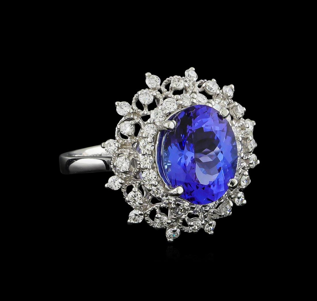 4.01 ctw Tanzanite and Diamond Ring - Platinum: One electronically tested platinum ladies cast tanzanite and diamond ring. The featured tanzanite is set within a stylized tiered diamond floret bezel, completed by a two and one-half millimeter wide 