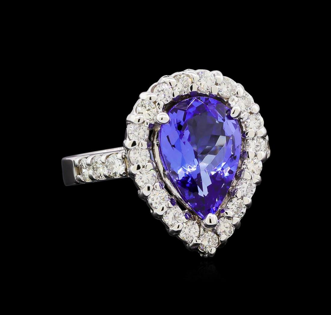 3.10 ctw Tanzanite and Diamond Ring - 14KT White Gold: One electronically tested 14KT white gold lady's cast fashion ring with a basket halo with a bright polish finish. The featured lady's ring has a shank measuring 3.15 millimeters in width. Identified 