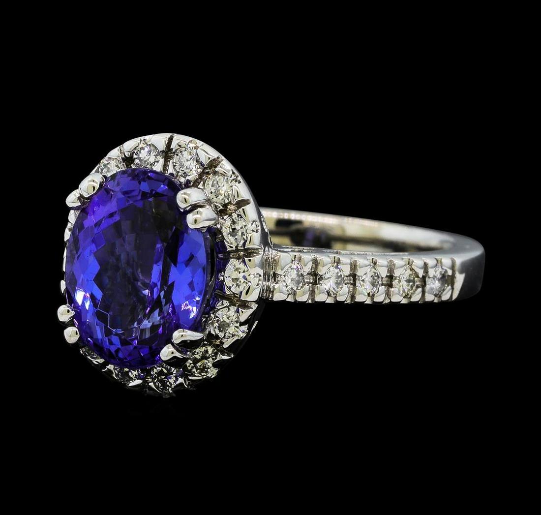 2.91 ctw Tanzanite and Diamond Ring - 14KT White Gold: One electronically tested 14KT white gold lady's cast fashion ring with a cathedral shank with a halo with a bright polish finish. The featured lady's ring has a shank measuring 2.25 millimeters wide.